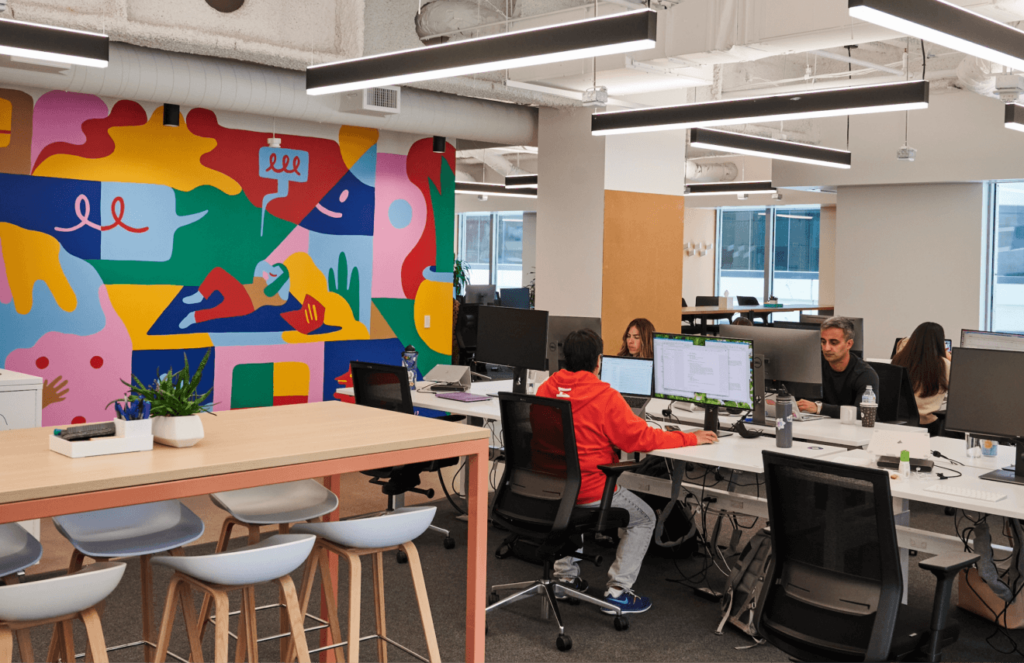 Interior of the Intercom office, showing a colourful wall mural and comfortable working space.